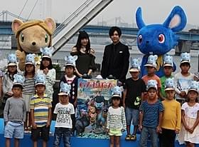 雨の中でウォーターキャノン砲の 水しぶきを浴びた梶裕貴と神田沙也加「GAMBA ガンバと仲間たち」