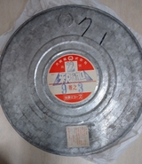 35mmの『釈迦』フィルム缶。映写技師宛に、国内でプリント焼付出来ないため取扱注意をお願いするシールが貼ってある