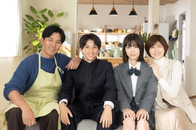 4人で仲睦まじく肩を寄せ合う家族写真