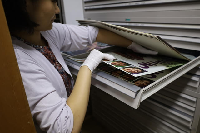 (画像上:2点)B2サイズのポスター出庫の様子。下にあるポスターは無理に引っ張ると破れる危険性がある。上のポスターの重さがかからないようにして取り出す