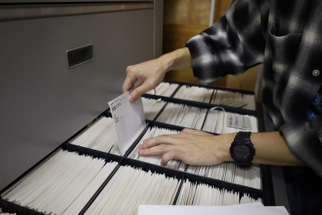 (画像上:3点)スチル写真の出庫の様子。可動式の保存棚を動かし、資料番号順リストを見ながらキャビネットから袋を取り出す