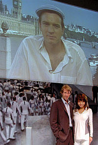 スクリーンに映るユアン・マクレガーと 会見場のベイ監督、花束贈呈役の釈由美子