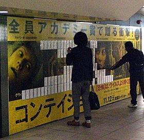 「コンテイジョン」感染予防マスクを手に取る通勤客「コンテイジョン」