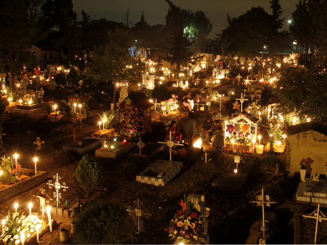 装飾した墓地に人々が集う「死者の日」