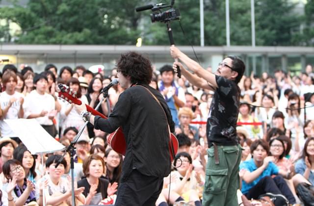 路上ライブを行った高橋優と撮影する園子温監督