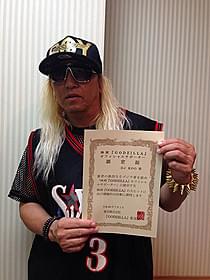 「GODZILLA」オフィシャルサポーターの 認定証を掲げるDJ KOO「ゴジラ」