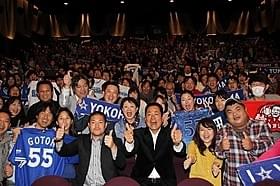 ファンとともに記念撮影を行った 中畑清監督(中央右)と後藤武敏選手「ダグアウトの向こう 今を生きるということ。」