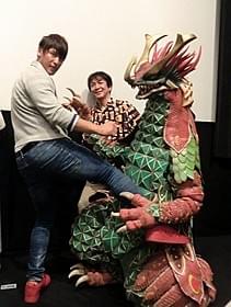 「大怪獣モノ」に蹴りを 入れる飯伏幸太(左)と河崎実監督「大怪獣モノ」